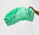 13 gallon MyEcoWorld Bag being held by a hand flowing in wind.